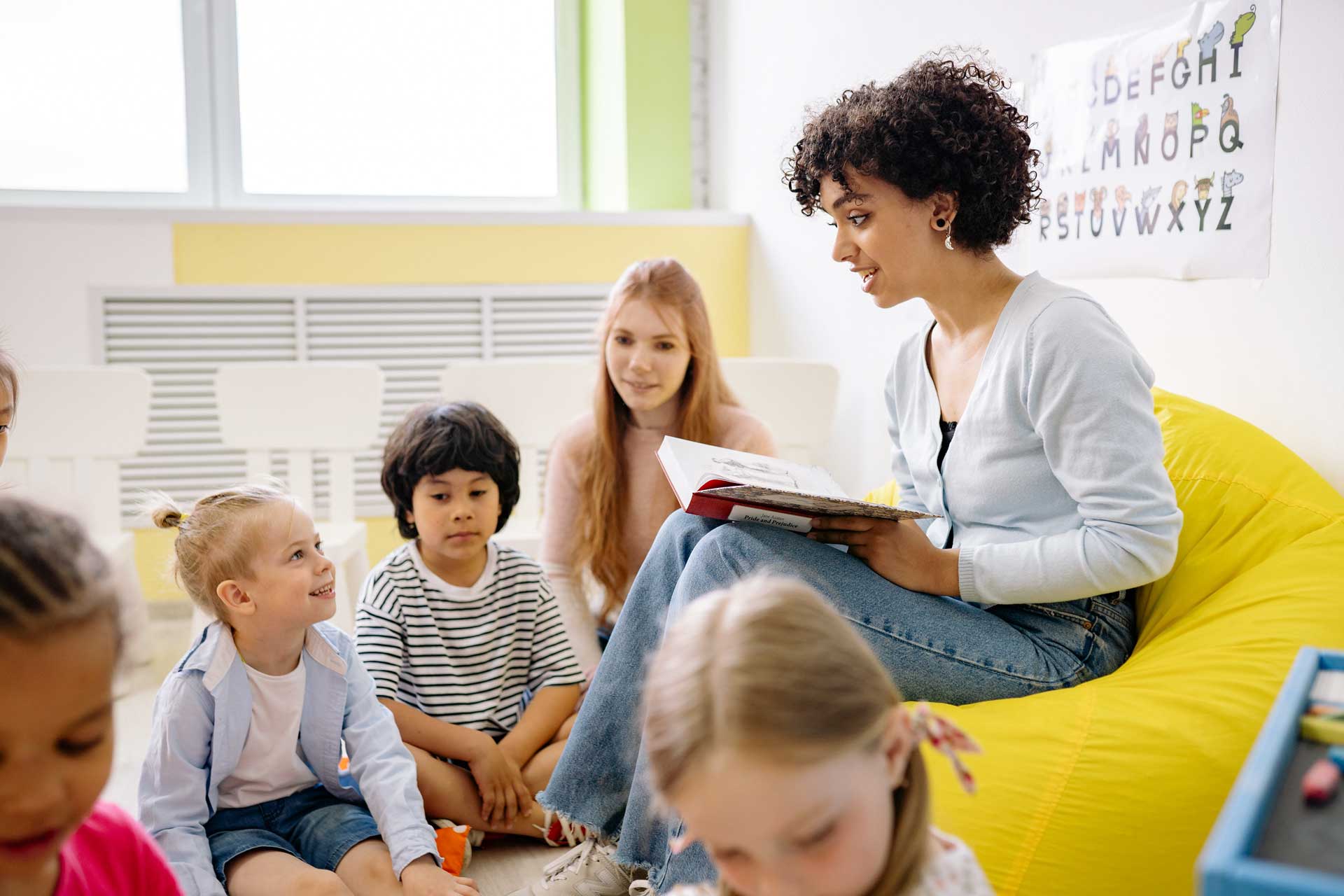 A teacher reading with a class of children.